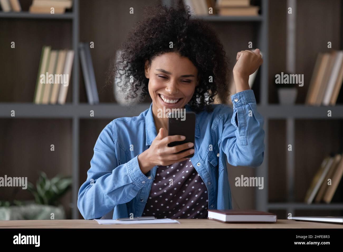 Glücklicher, fröhlicher Smartphone-Nutzer, begeistert von guten Nachrichten Stockfoto
