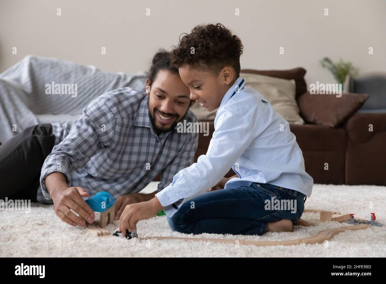 Happy Black Vater und niedlichen lockigen behaarten Sohn spielen zusammen Stockfoto