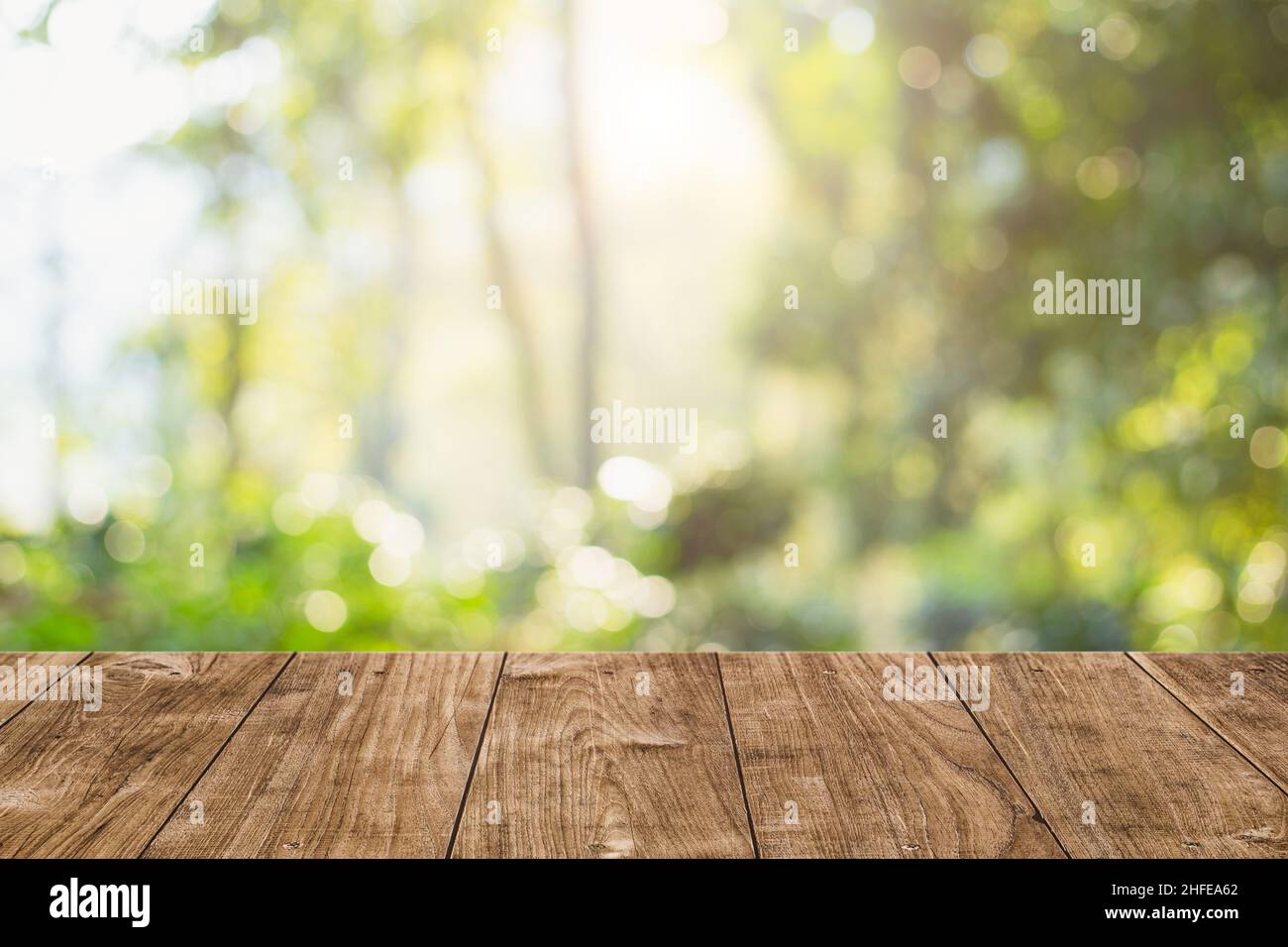 Grüne Natur mit Holztisch Platte Blur Morgen Licht Wald für Montage Produkte Display Werbung Hintergrund Stockfoto
