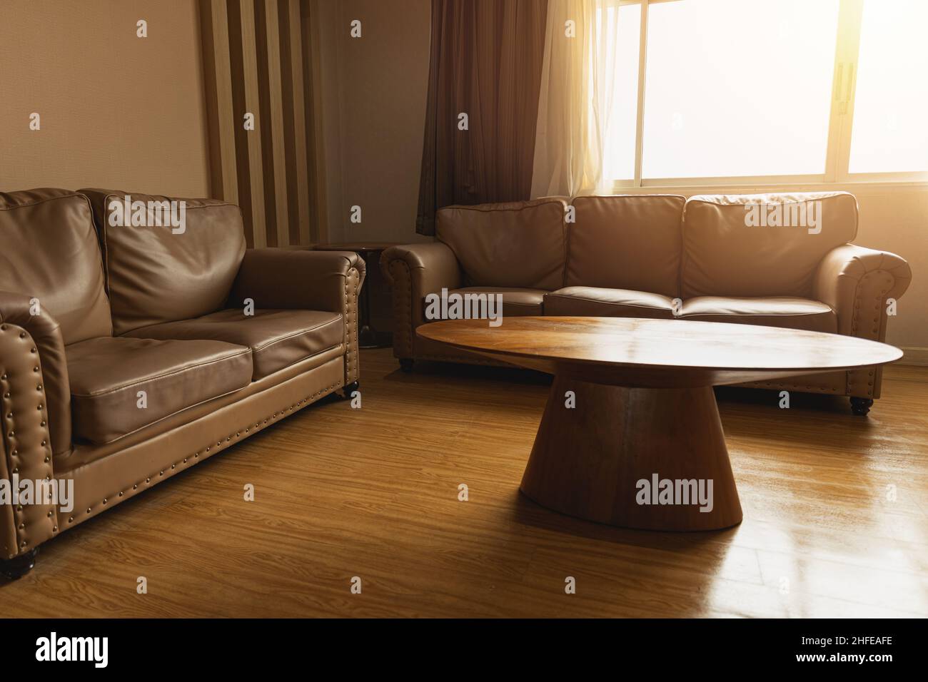 Wohnzimmer oder Warteraum Ledersofa mit Holztisch Vintage-Stil Dekoration braunen Farbton Stockfoto