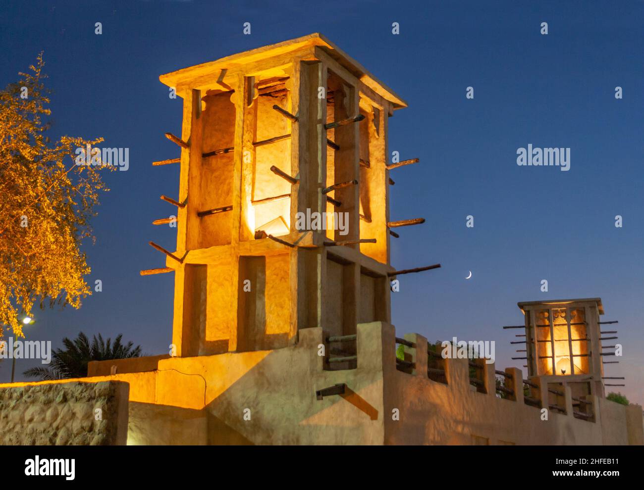 Traditionelle Windtürme, die bei Nacht im Dubai Heritage Village in den VAE fotografiert wurden. Die Türme fangen die kühlere Brise über dem Boden. Stockfoto