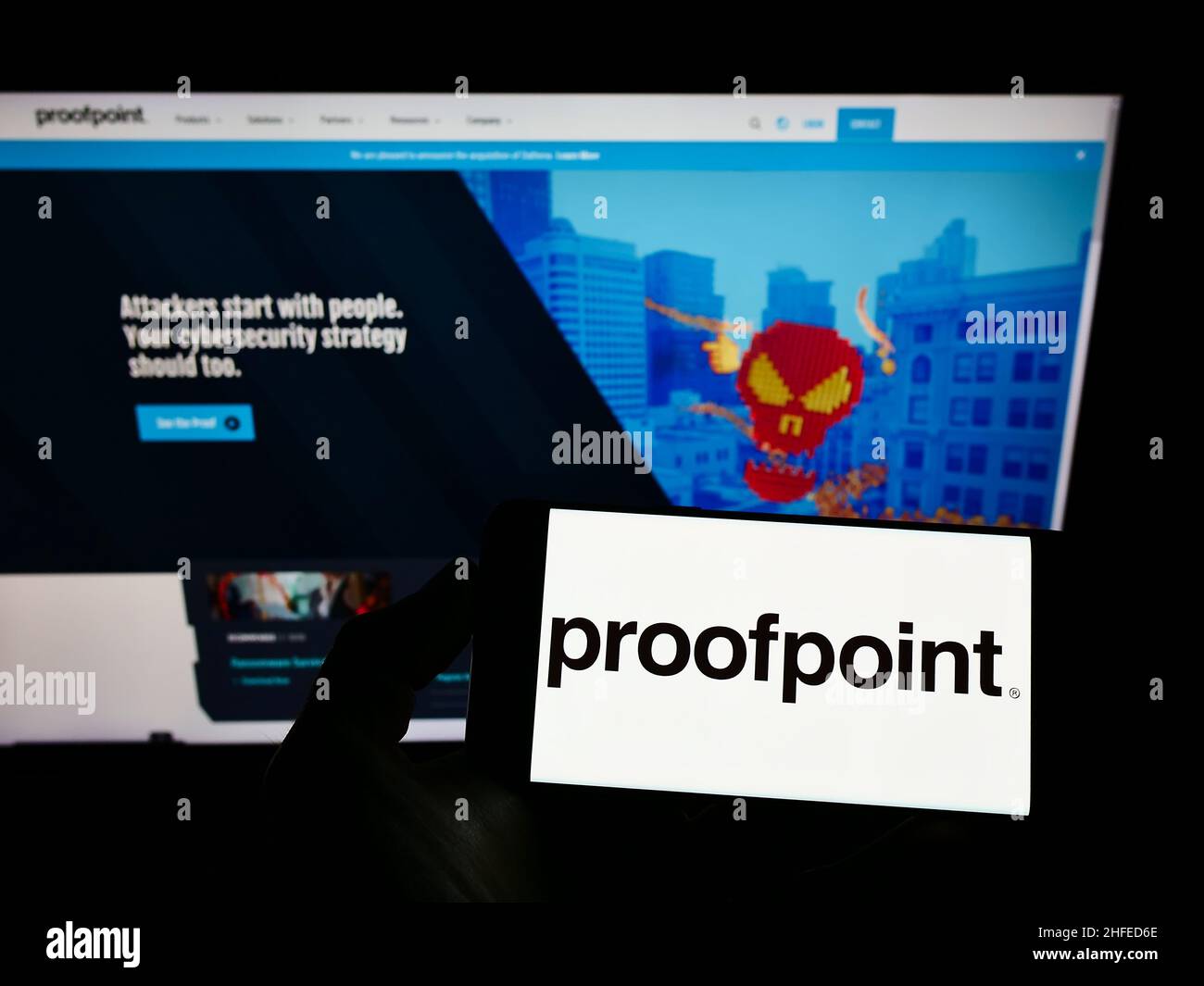 Person, die ein Mobiltelefon mit dem Logo des US-amerikanischen Sicherheitssoftware-Unternehmens Proofpoint Inc. Auf dem Bildschirm vor der Webseite hält. Konzentrieren Sie sich auf die Telefonanzeige. Stockfoto