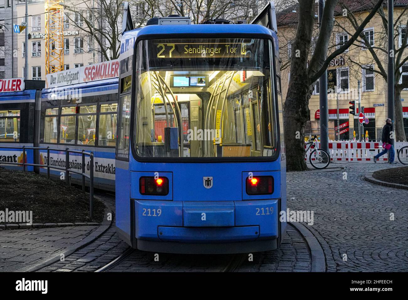 Am Bahnhof Sendlinger Tor in München steht eine blaue Straßenbahn. Stockfoto