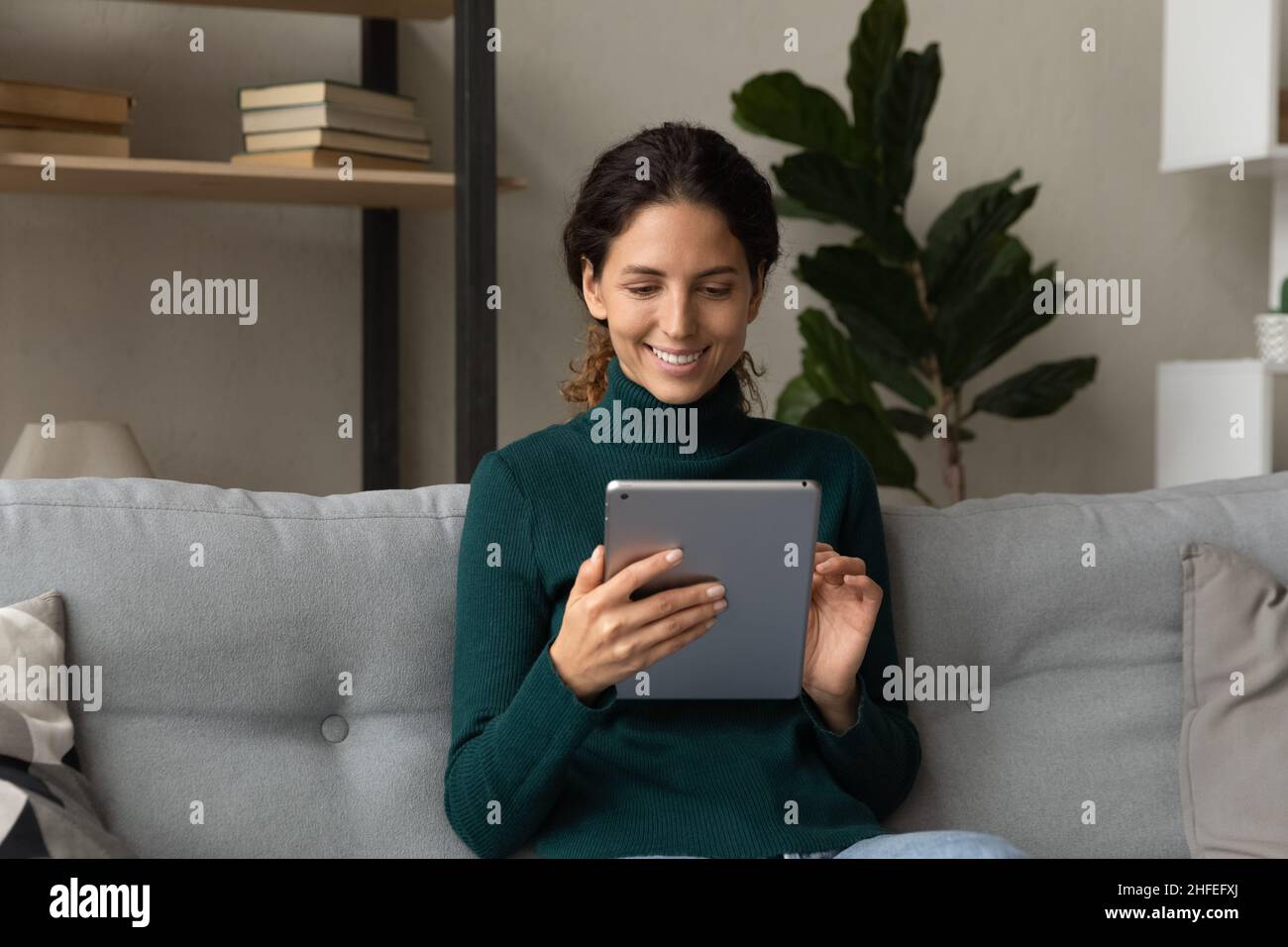 Glückliche junge lateinerin mit digitalem Tablet. Stockfoto