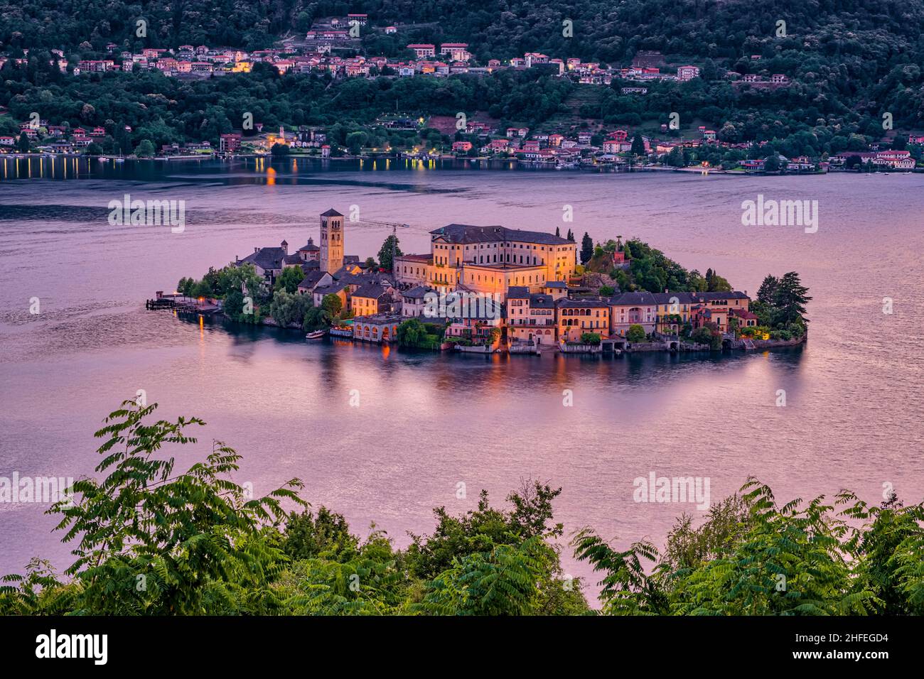 Luftaufnahme vom Sacro Monte auf der Insel St. Julius mit der Basilica di San Giulio mitten im Ortasee, nachts beleuchtet. Stockfoto