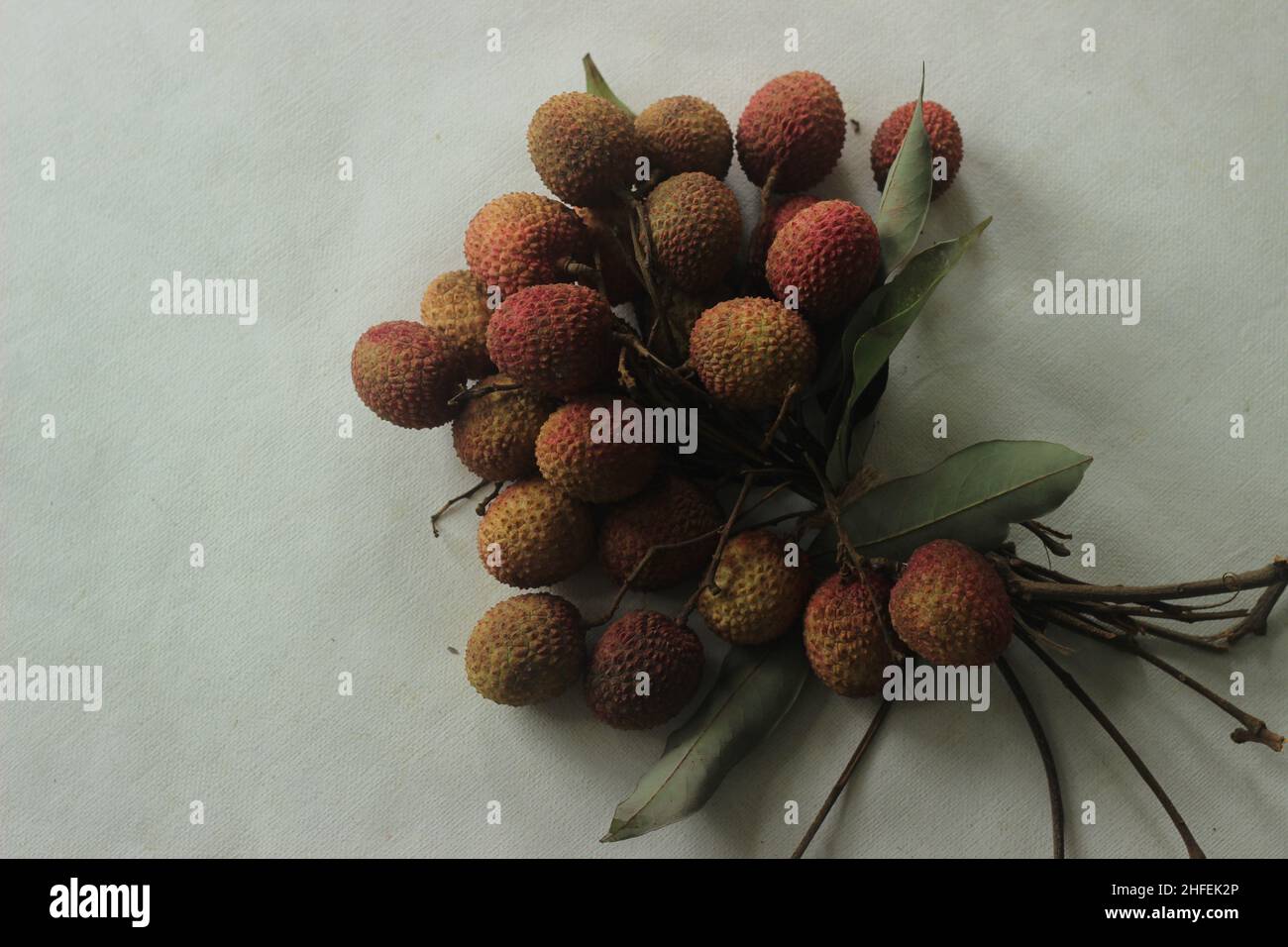 Litschi-Früchte auf weißem Hintergrund aufgenommen. Litchi chinensis auch buchstabiert litchi oder lichi, ist ein immergrüner Baum der Familie der Speckbeere oder Sapindaceae, gr Stockfoto