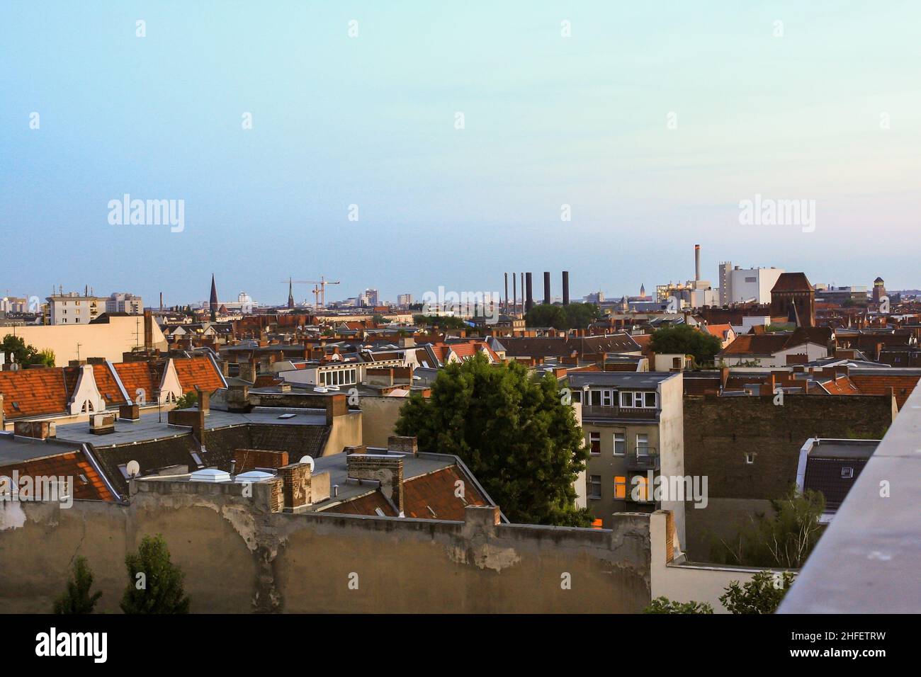 Luftaufnahme des Dachs mit Blick auf die Berliner Stadtlandschaft am Sommerabend mit Wolken im Hintergrund des blauen Sonnenuntergangs. Keine Personen. Stockfoto