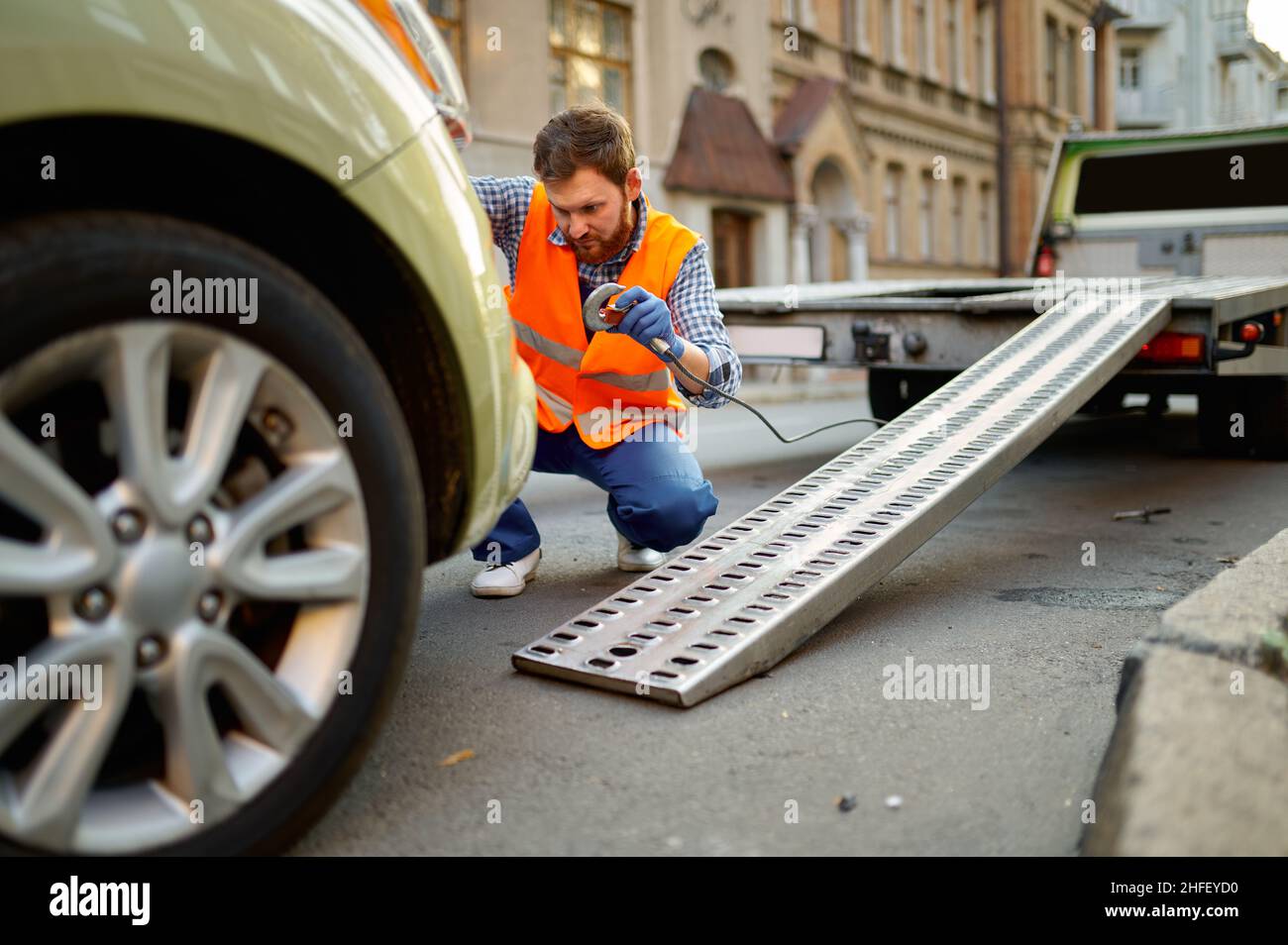 Straßenarbeiter, der das Auto für die Evakuierung vorbereitet Stockfoto