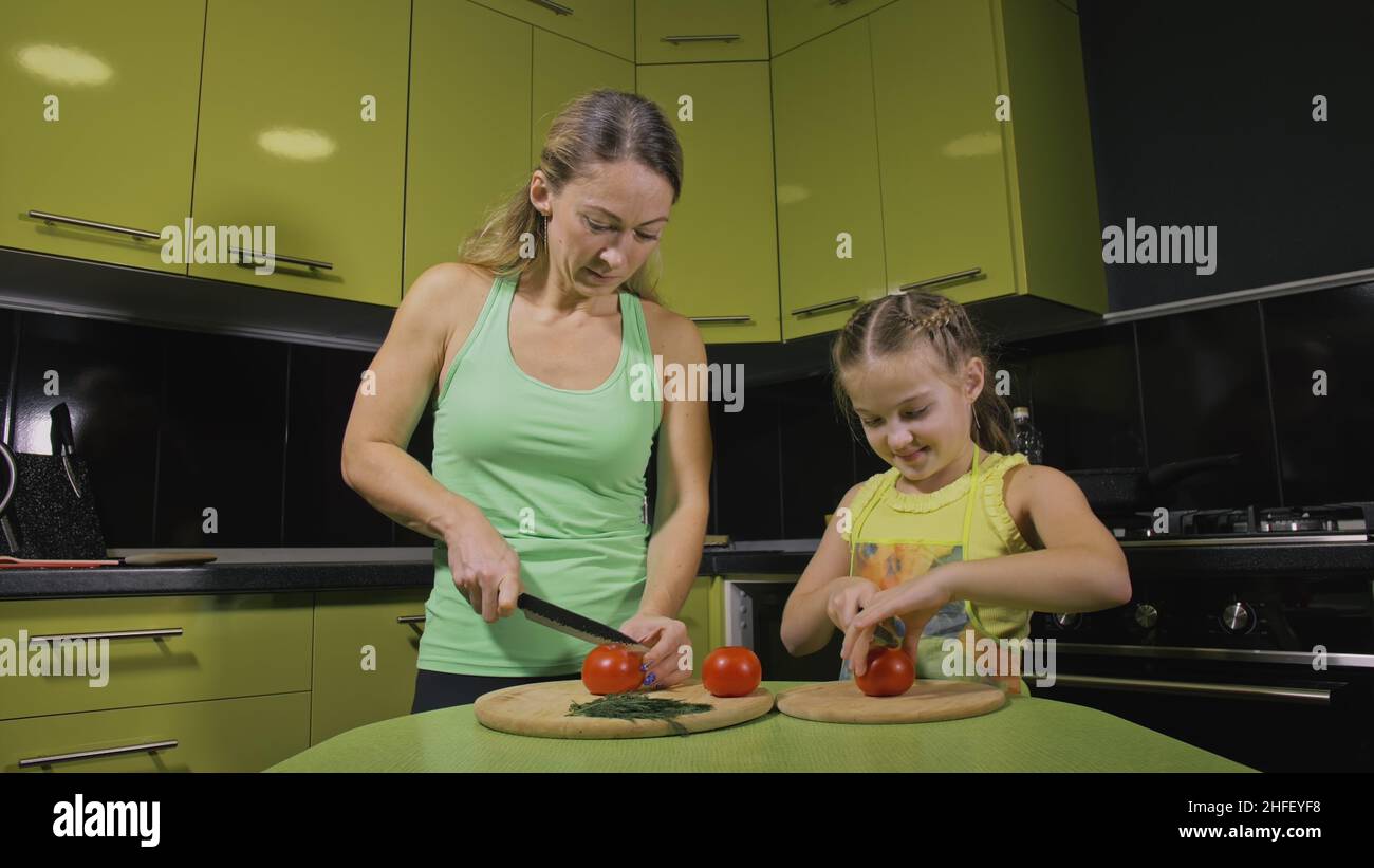 Mutter lehrt Tochter smart Mädchen zu kochen lernen. Junge Herrin ...