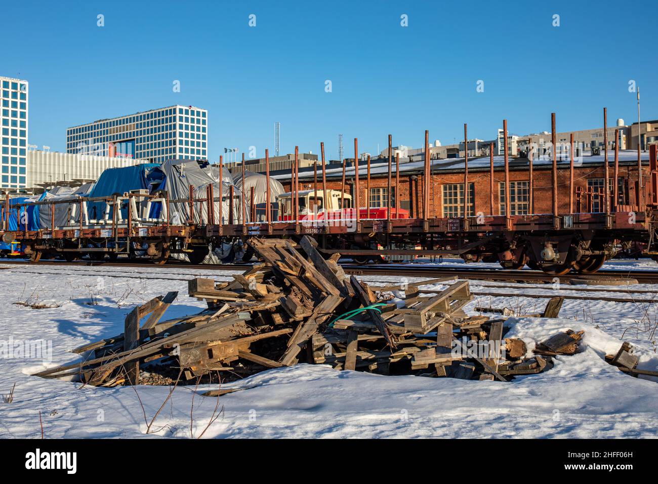 Stapel zerbrochener Paletten im Schnee auf dem alten Eisenbahnhof im Stadtteil Pasila in Helsinki, Finnland Stockfoto