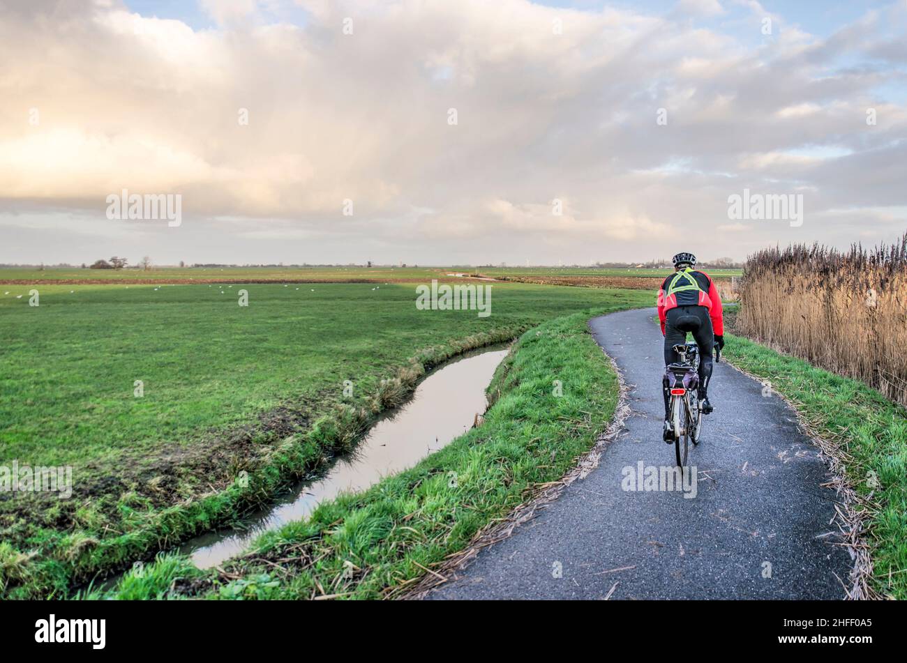 Schoonhoven, Niederlande. 9. Januar 2022: Ein Schnellfahrer auf einem kurvigen Asphaltweg durch den Krimpenerwaard Polder Stockfoto