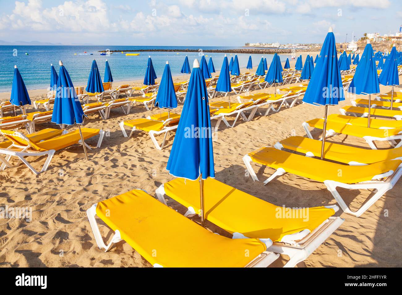 Sonnenschirme und leere Liegen am Strand bei Morgenlicht Stockfoto