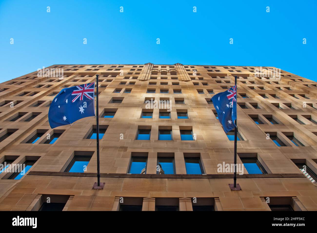 Zwei australische Flaggen hängen an einem Sandsteingebäude Stockfoto