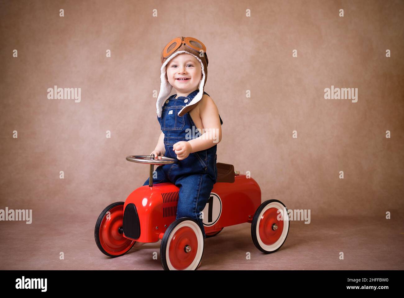 Kind fährt im roten Auto. Kind mit Weihnachtstasche. Weihnachtsfeiertagskonzept Stockfoto