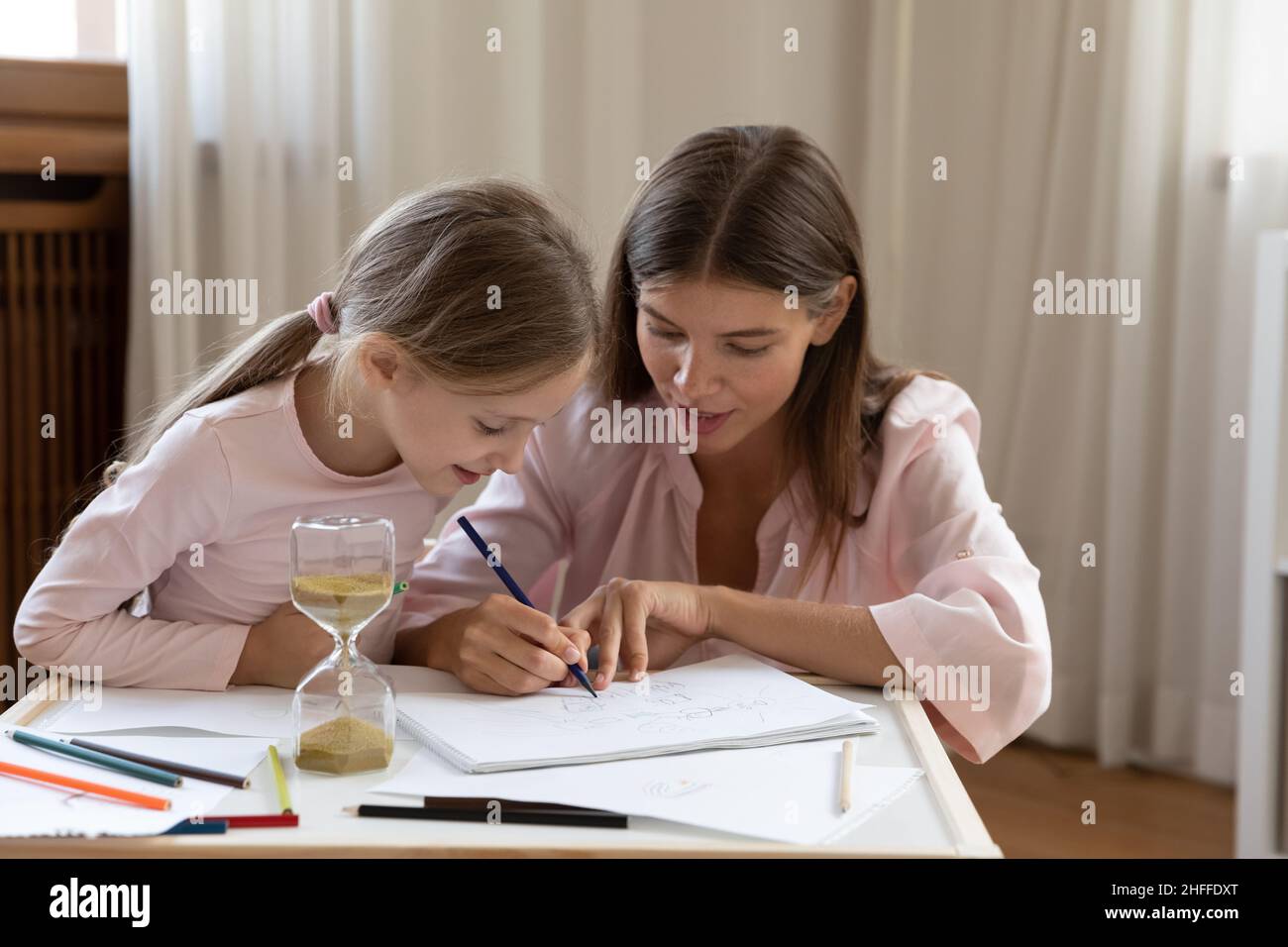 Mutter und Tochter zeichnen im Skizzenbuch mit Buntstiften Stockfoto