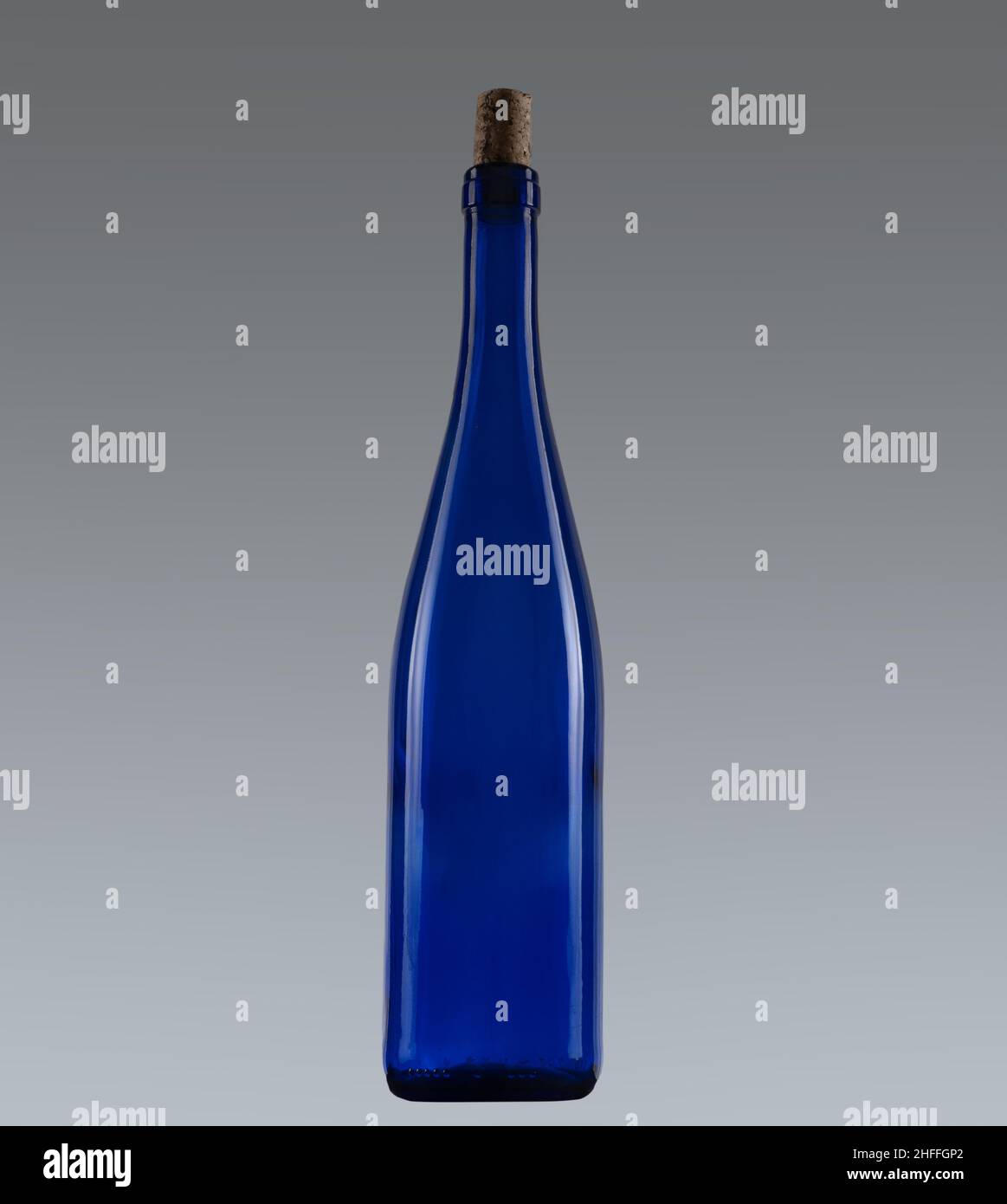 Blaue Weinflasche mit Kork, auf grauem Hintergrund. Stockfoto