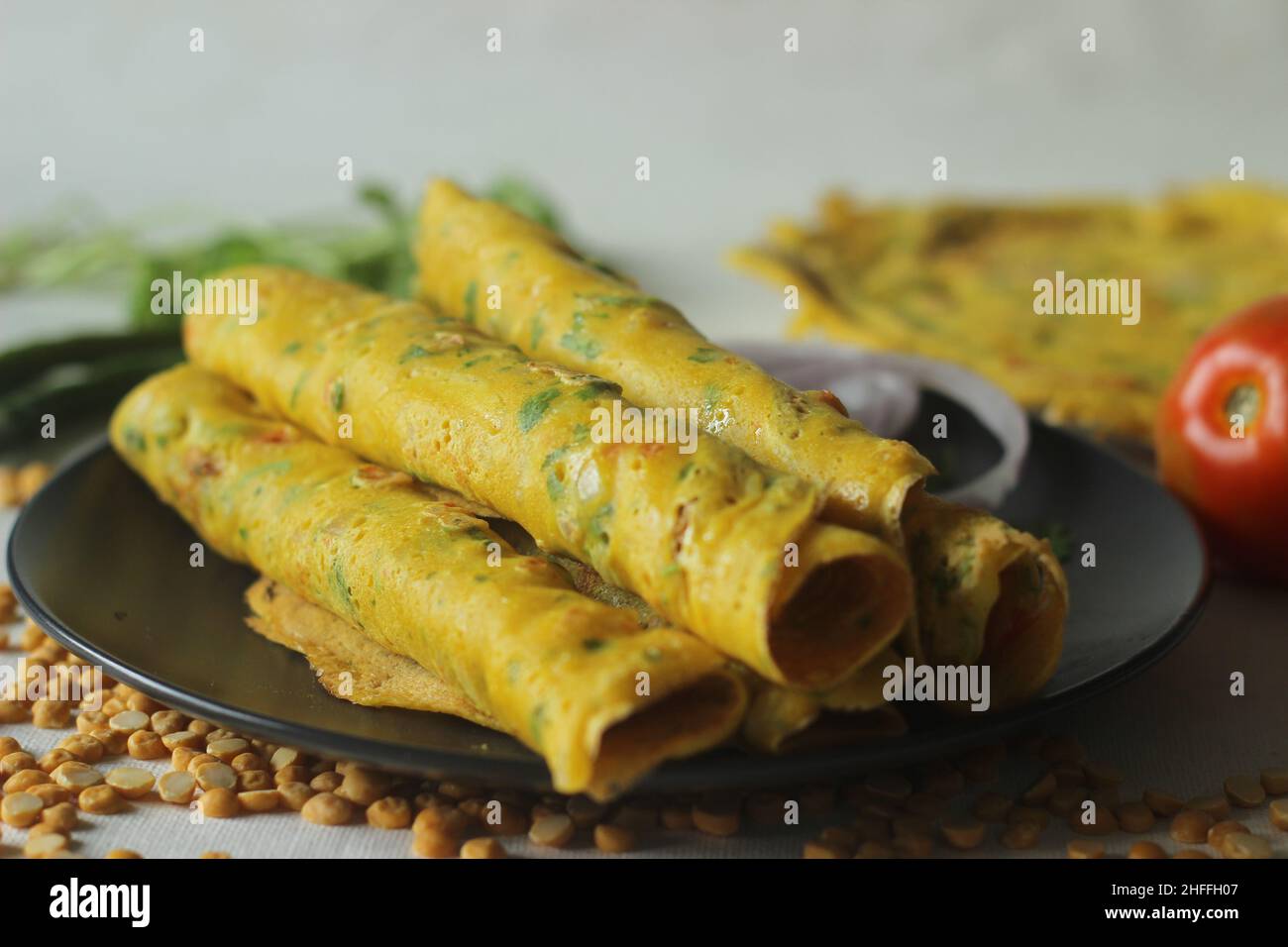 Pfannkuchen mit Besan chilla oder Kichererbsen. Dies sind eiweißreiche, herzhafte Pfannkuchen aus Besanmehl oder Kichererbsenmehl mit Zwiebeln, Tomaten, grünem Chili und Stockfoto