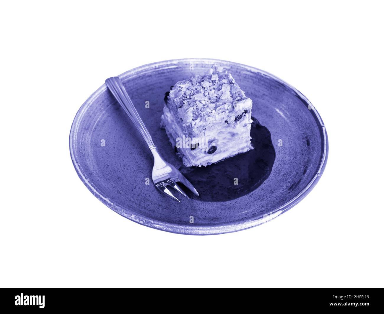 Dessert, ein Stück Kuchen auf einem Teller mit einer Dessertgabel. Farbe des Jahres 2022 Very Peri 17-3938 TCX. Farbcodes: SRGB, CMMK, HEX, LAB. Minimalistisches p Stockfoto