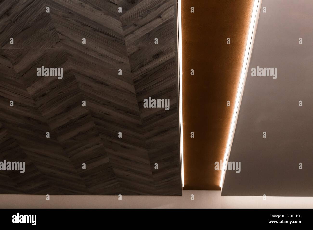 Modernes Renovierungsdesign und Element der Holzdecke mit Beleuchtung des Innenraums des Raumes. Stockfoto