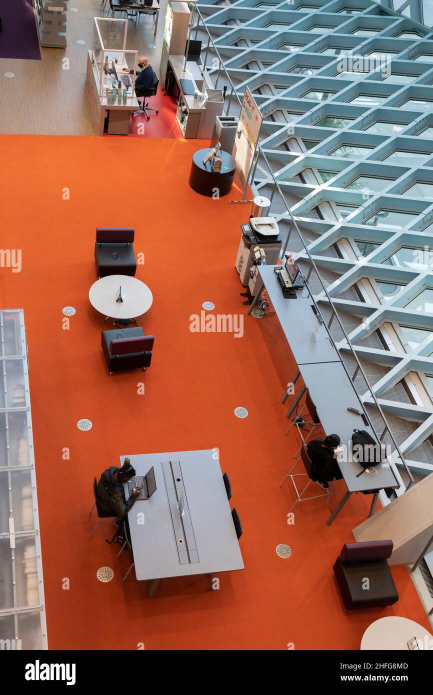 Besucher nutzen die Einrichtungen im Erdgeschoss „Wohnzimmer“ der Seattle Central Library in der Innenstadt von Seattle. Stockfoto