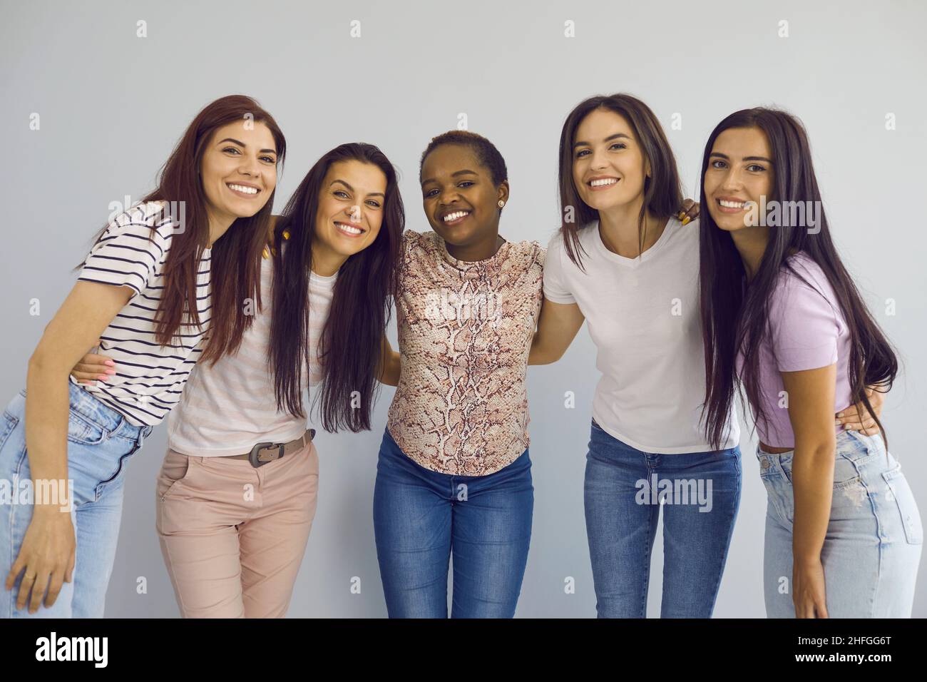 Porträt einer Gruppe glücklicher junger Frauen, die sich aufrichtig umarmen und lächeln. Stockfoto