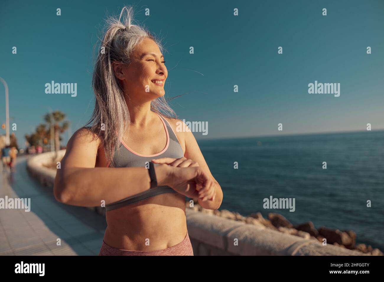 Starke schlanke Frau, die am Wasser steht Stockfoto