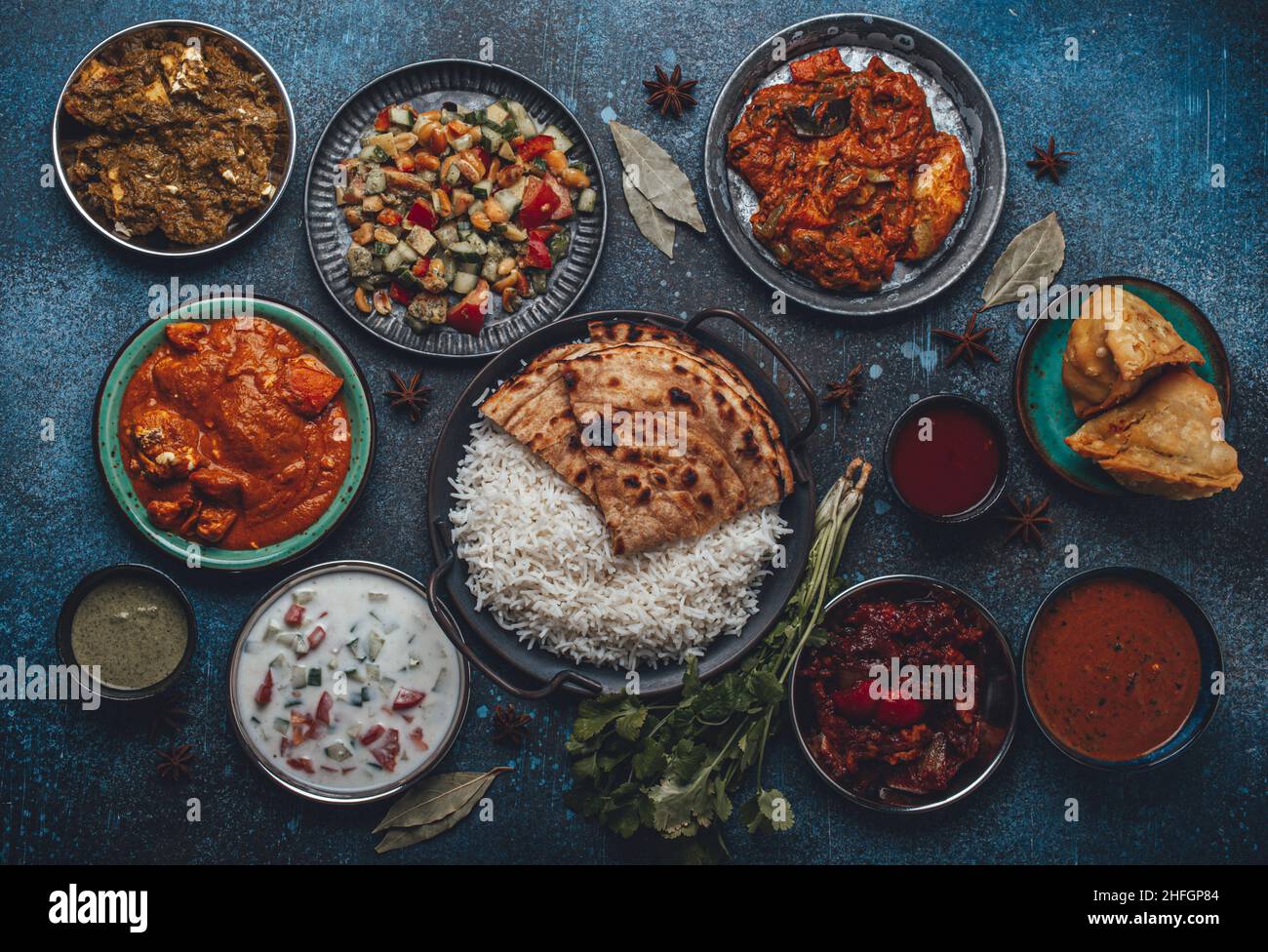 Gemischtes indisches Buffet mit ethnischen Gerichten auf rustikalem Betontisch von oben Stockfoto