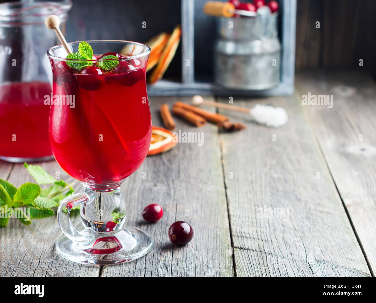 Frischer Cranberry-Saft mit Zimt und Anis in Glasgefäßen auf altem Holzhintergrund. Selektiver Fokus. Stockfoto