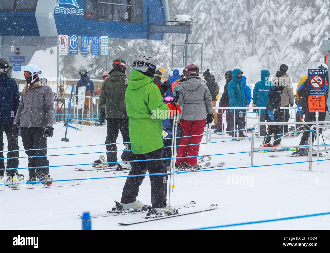 Skifahrer in der Skiregion stehen in einer Schlange vor einer Liftstation im Mt Seymour Ski Resort BC, Kanada-Februar 4,2021. Straßenansicht, Reisefoto, Stockfoto