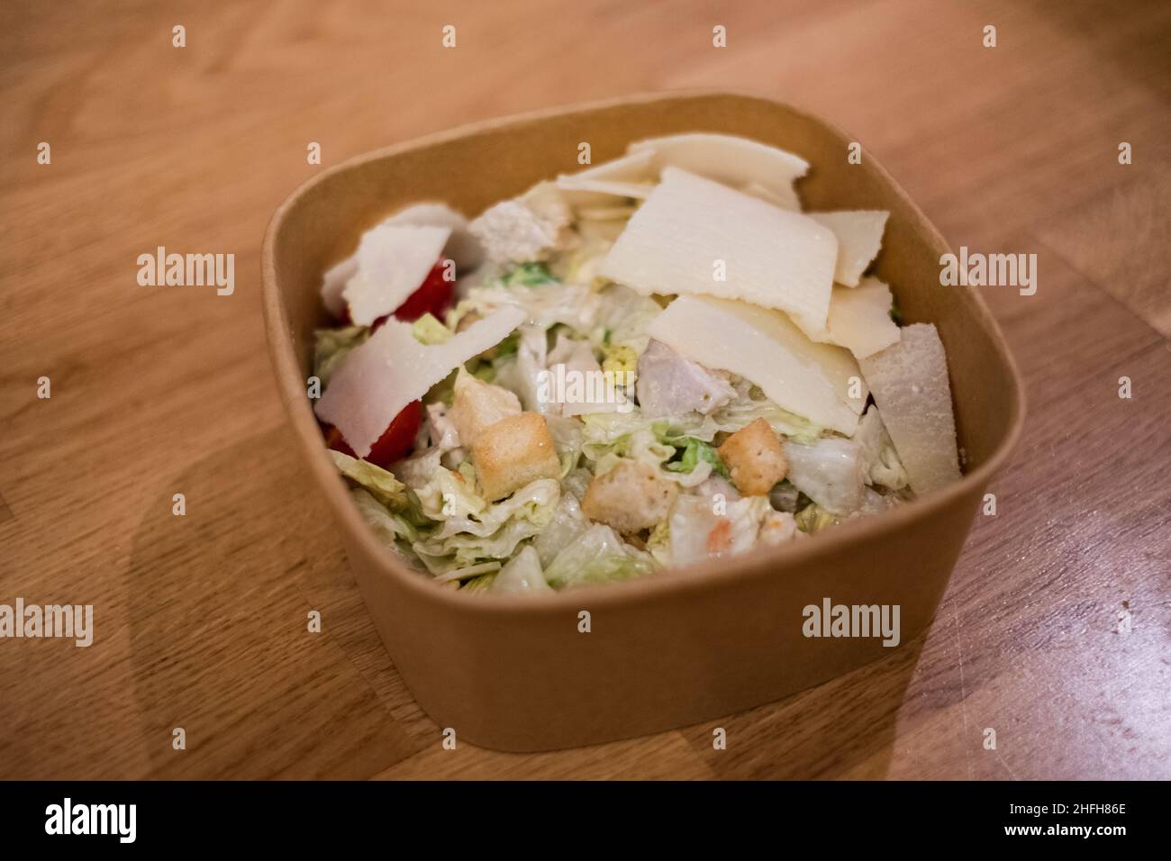 Köstlicher frischer Hühnersalat in einem braunen Lebensmittelbehälter. Stockfoto