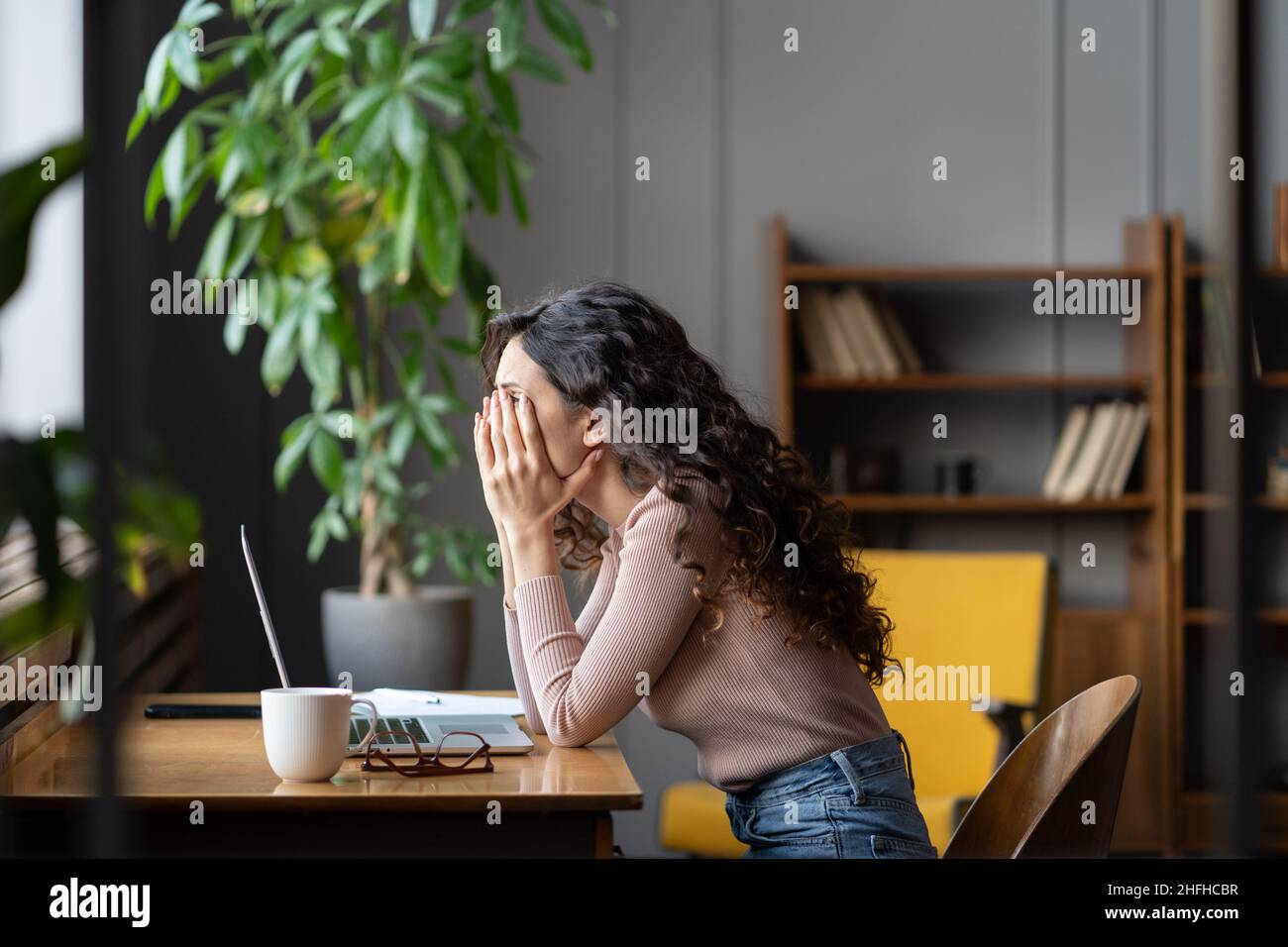 Enttäuschte weibliche Büroangestellte, die sich durch Aufgaben kämpfte, müde überarbeitete weibliche Angestellte Stockfoto
