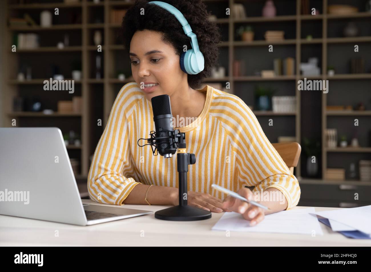Konzentrierte afroamerikanische weibliche Radiosendung Moderatorin, die im Büro arbeitet. Stockfoto