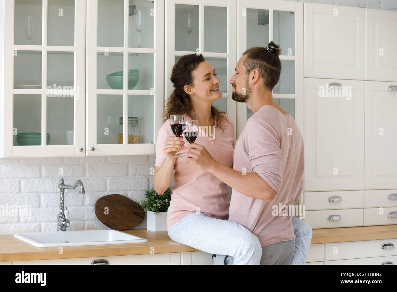 Glücklich liebende junge Familie Paar klirrende Weingläser. Stockfoto