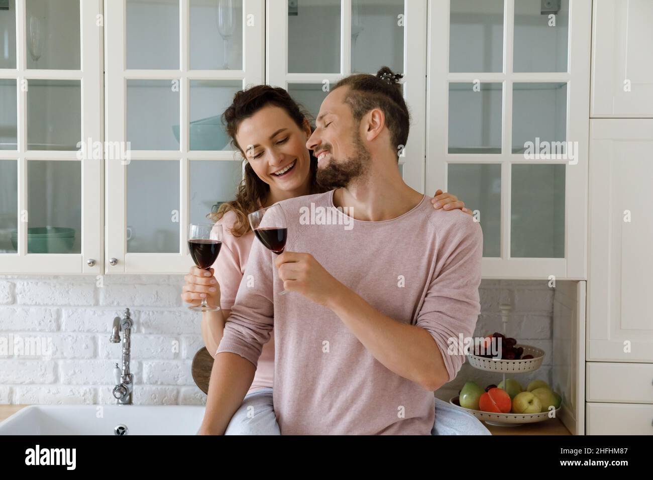 Glückliches Familienpaar klirrrende Gläser, Dating zu Hause. Stockfoto