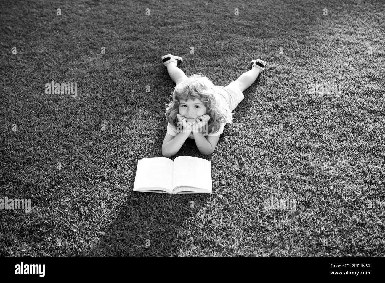 Nettes, schönes Kinderbuch draußen. Kinder lesen im Park ein Buch. Stockfoto