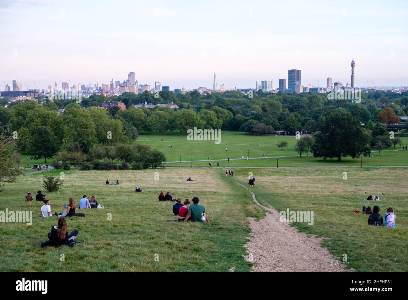 Die Menschen genießen den Blick auf die Skyline von London vom Primrose Hill aus Stockfoto