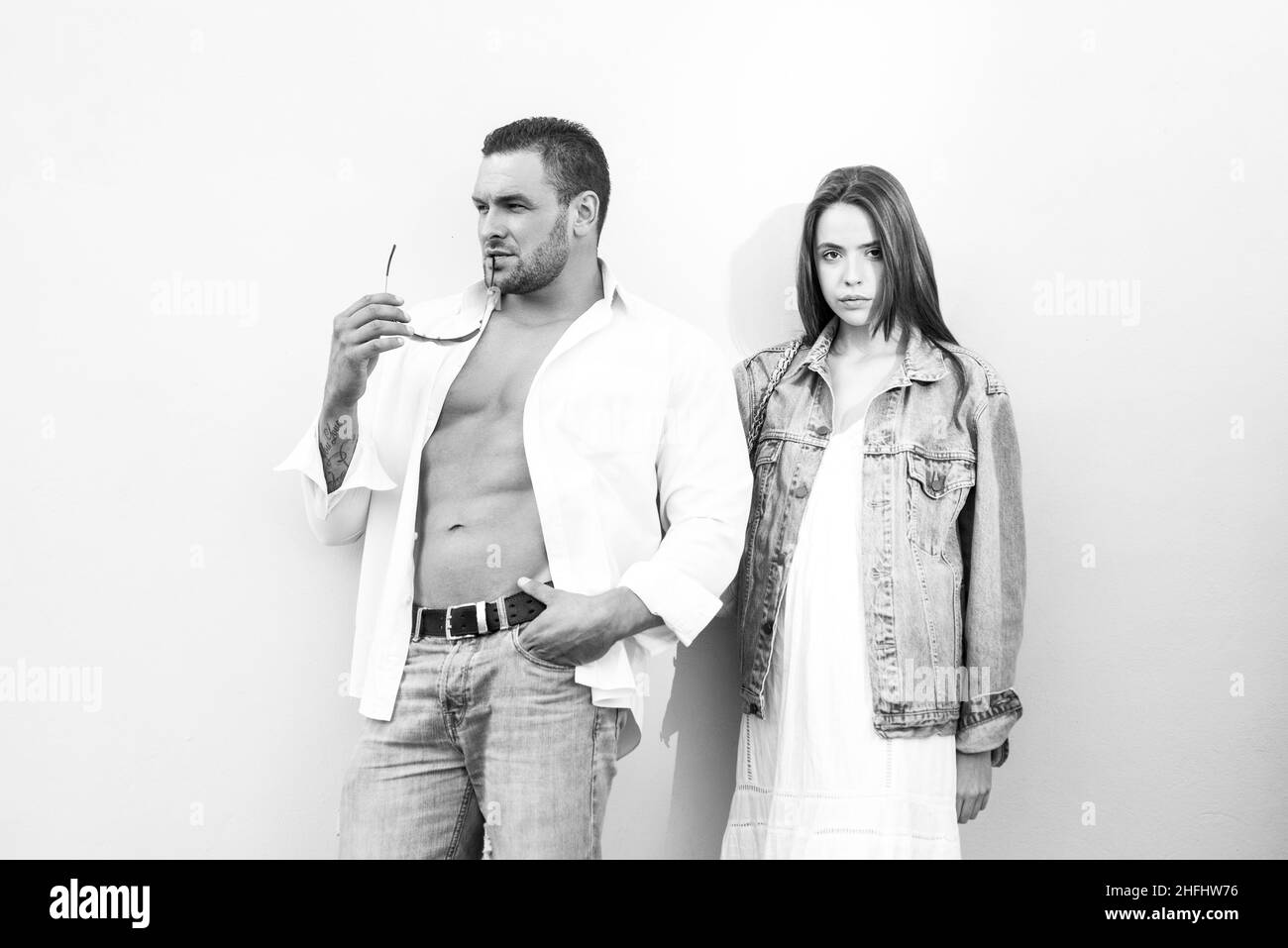 Paar Mode Jeans Konzept. Schöne Paar in Denim tragen Bindung auf blauem Hintergrund. Stockfoto