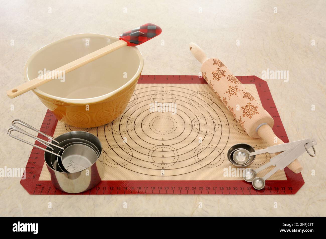 Backgeräte mit Schüssel und Silikonmatte zur Vorbereitung auf das Backen. Horizontales Format auf neutralem Hintergrund. Stockfoto