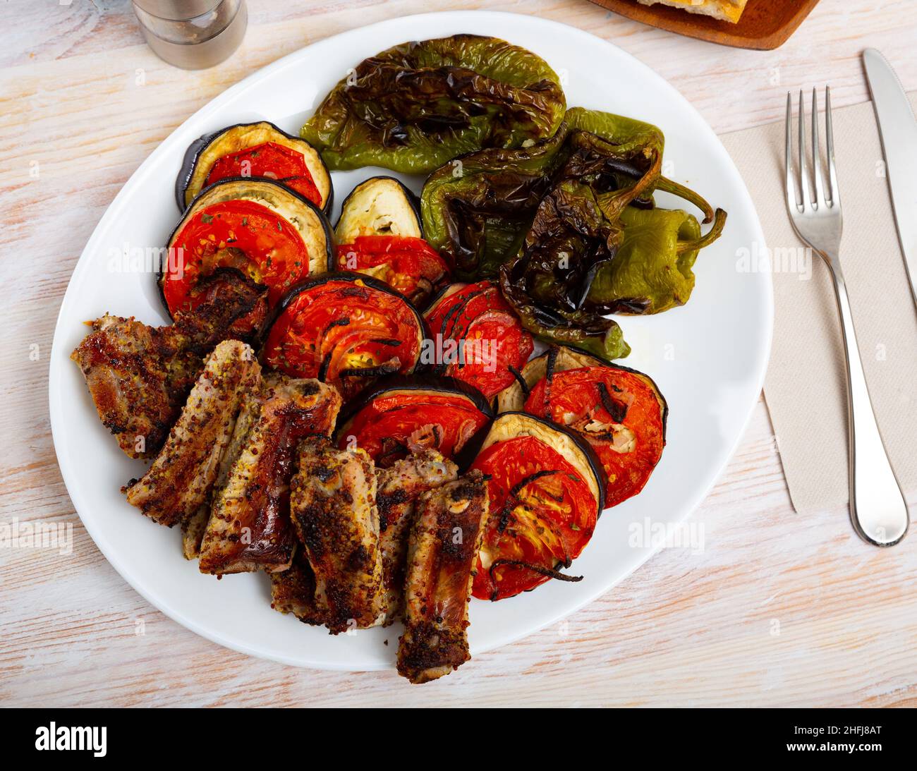Gegrillte Schweinebrippen in Senf und Gemüse Stockfoto
