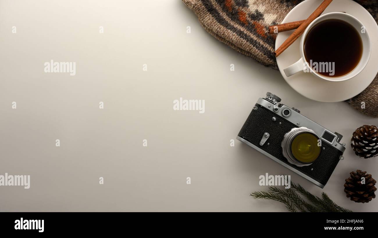 Minimalistischer Büroschreibtisch-Arbeitsplatz-Hintergrund mit Kamera, Kaffeetasse, Dekor und Kopierfläche für Präsentationen auf weißem Hintergrund. Draufsicht Stockfoto