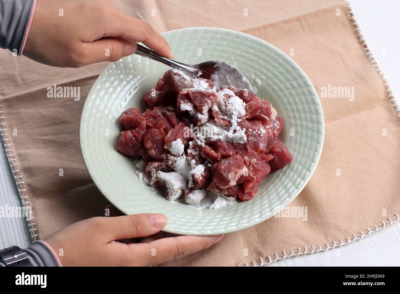 Weibliche asiatische Hand Coating Fleisch mit Mehlmischung vor dem Kochen Prozess, Schritt für Schritt machen asiatische Rindfleisch Rezept Stockfoto