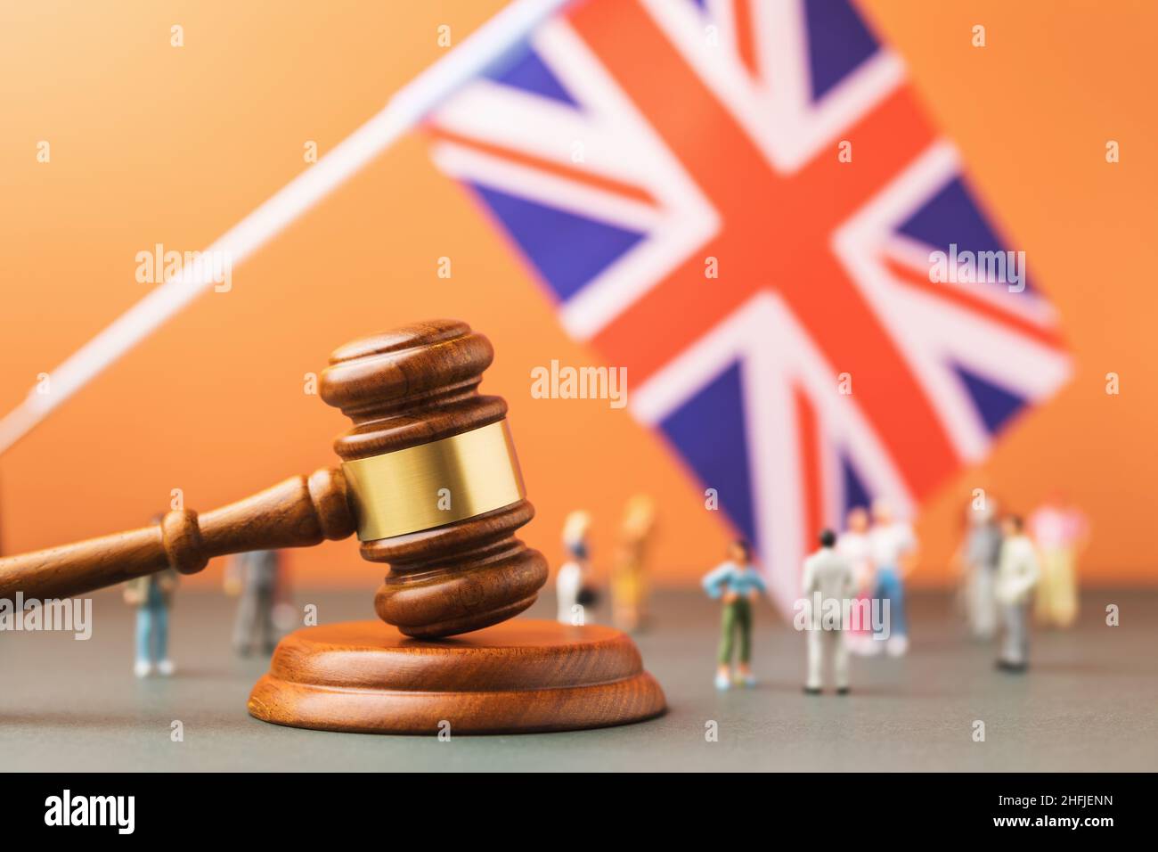 Hölzerne Richter gavel, Flagge und Kunststoff-Spielzeug auf einem farbigen Hintergrund, das Konzept der Prozesse in der British Society Stockfoto