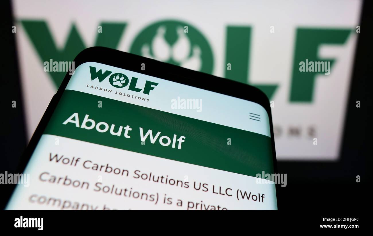 Mobiltelefon mit Website der Firma Wolf Carbon Solutions auf dem Bildschirm vor dem Firmenlogo. Konzentrieren Sie sich auf die obere linke Seite des Telefondisplays. Stockfoto