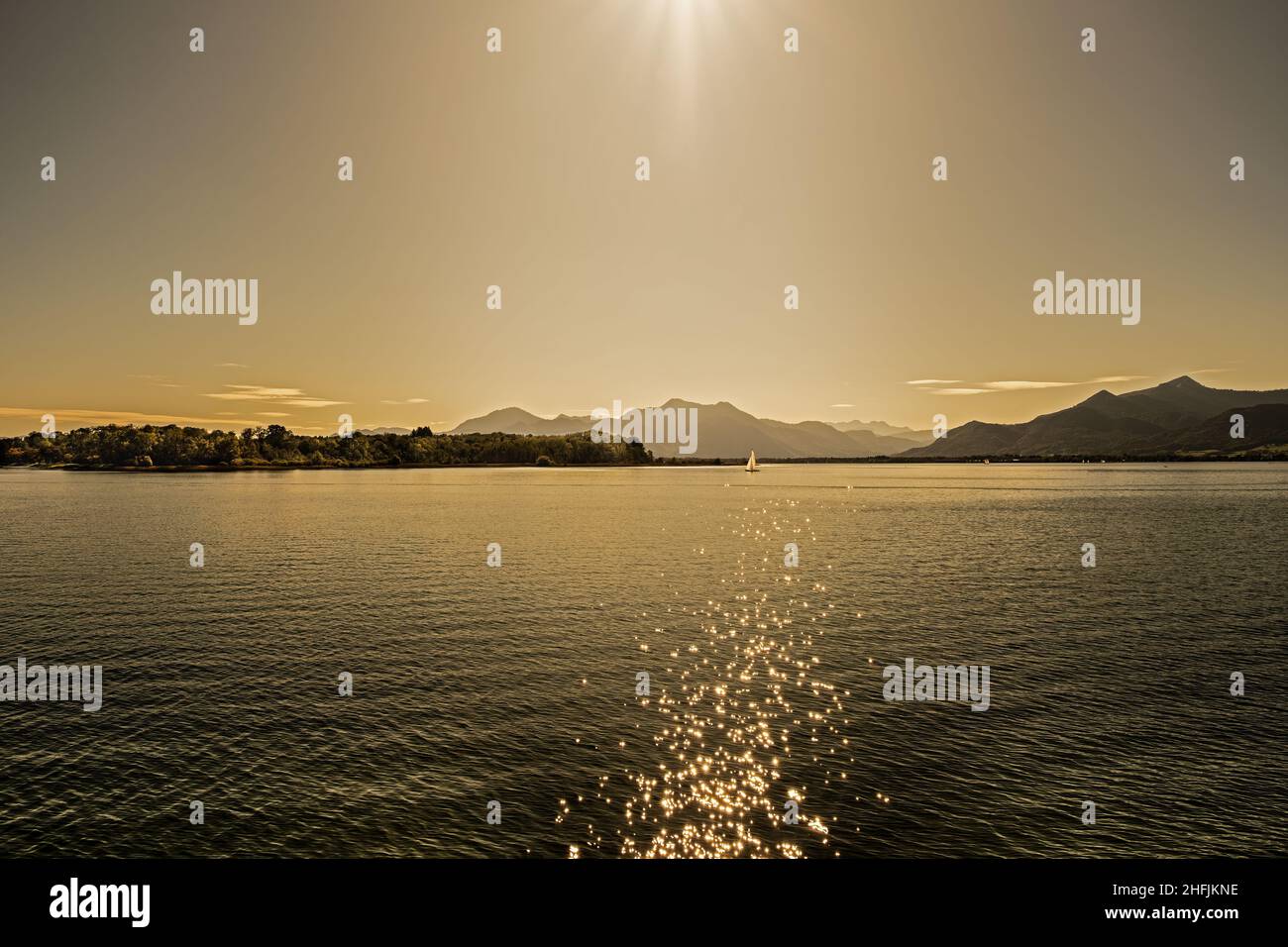 Blick auf den Chiemsee mit einem Segelboot bei Sonnenuntergang Stockfoto