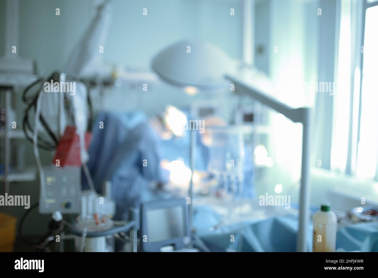 Unfokussierter Hintergrund mit Chirurgen, die einen chirurgischen Notfallvorgang auf der Intensivstation durchführen. Stockfoto
