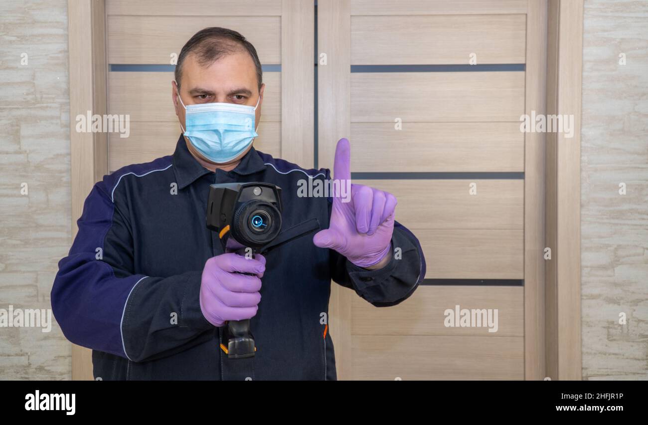 Person misst die Temperatur mit einer Wärmebildkamera. Epidemiologische Situationsüberwachung. Temperaturkontrolle Stockfoto
