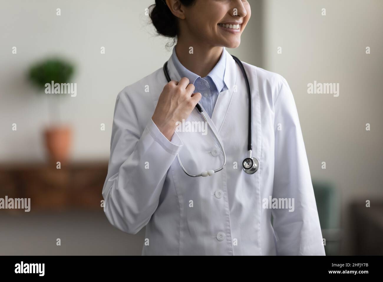 Nahaufnahme lächelnder indischer Arzt posiert im Klinikbüro. Stockfoto