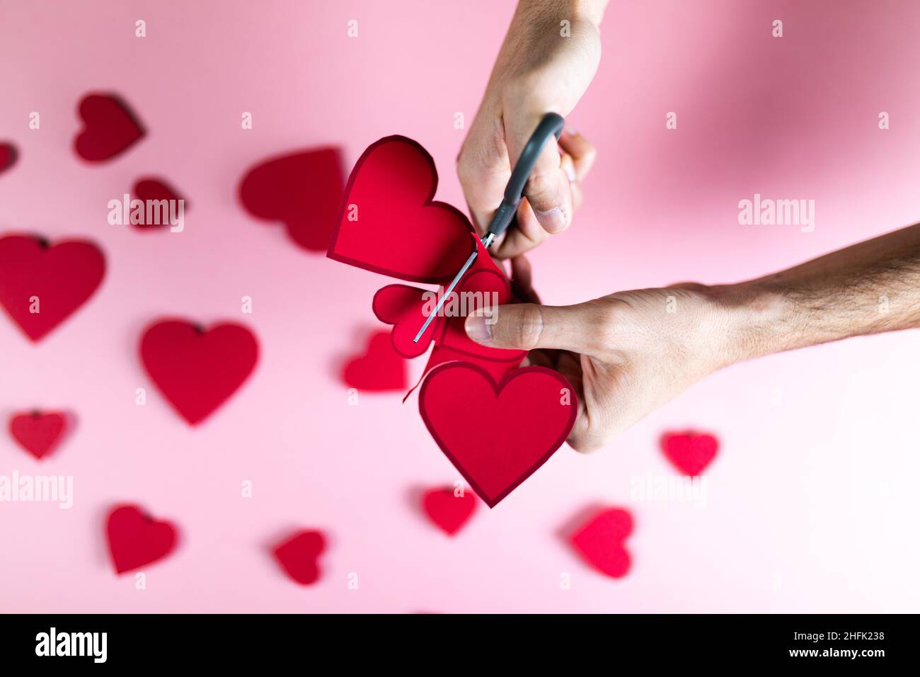 Guy bereitet Red Heart mit Papier für den Valentinstag vor Stockfoto