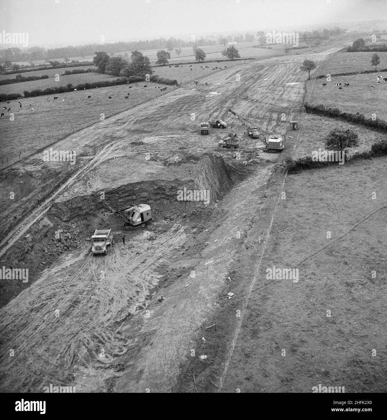 Luftaufnahme der Aushubarbeiten für den Bau der London to Yorkshire Motorway (M1), 10/06/1958. Eine Luftaufnahme von Baufahrzeugen, die Aushubarbeiten für den Bau der London to Yorkshire Motorway durchführen (M1). In diesem Bild lädt eine 43 RB-Schaufel im Vordergrund einen Euclid-Heckkipper. Im Hintergrund lädt eine Dragline mit 22 RB 5-Tonnen-Lkw. Stockfoto