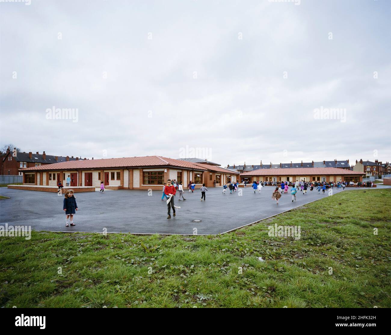 Harehills Primary School, Markham Avenue, Harehills, Leeds, 09/03/1989. Harehills Primary School, Leeds, Blick nach Norden, mit Kindern auf dem Spielplatz. Alle Dokumente von Laing über den Vertrag beziehen sich auf die Harehills Primary School, aber anderswo ist sie als Bankside Primary School bekannt. Es ist unklar, wann dies zum offiziellen Namen der Schule wurde. An der Darfield Road gibt es eine andere Schule namens Harehills Primary School. Es wurde nach der gleichen Vorlage gebaut, ist aber ein Spiegelbild der Markham Avenue Website. Bankside Primary wurde abgerissen und zwischen 2009 und durch ein größeres modernes Schulgebäude ersetzt Stockfoto